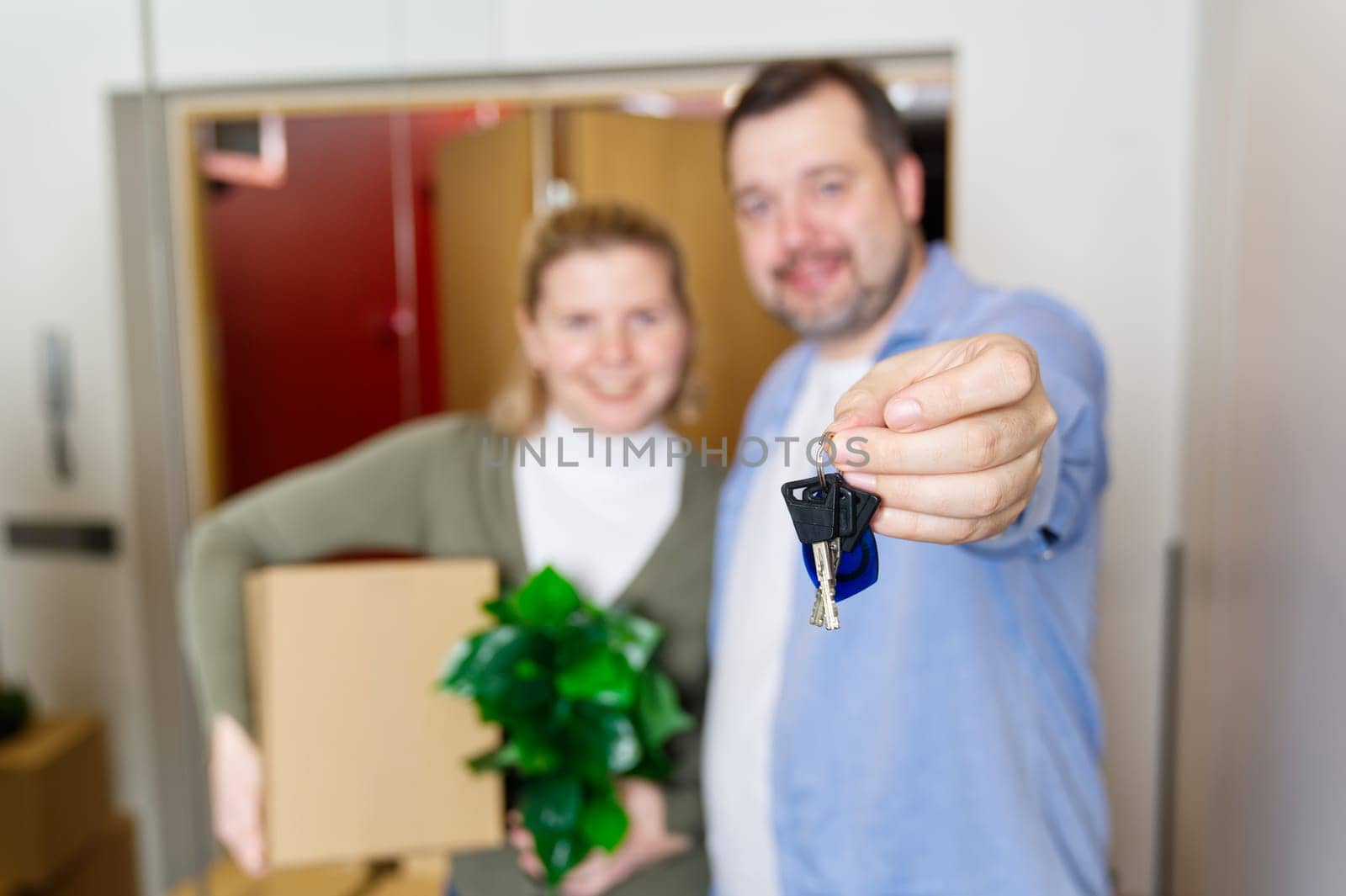 Couple showing keys to new apartment. real estate mortgage, loan concept. moving in new house. Young smiling couple holding their new house keys. first own apartment or house.