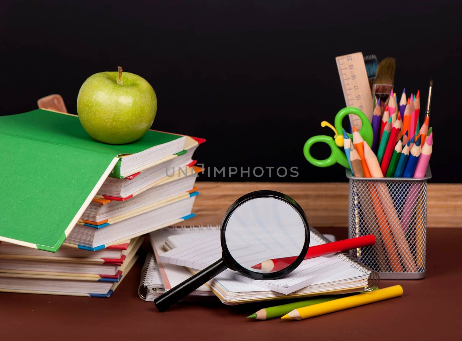 board, books, pencils, opened empty notebook against a dark by aprilphoto