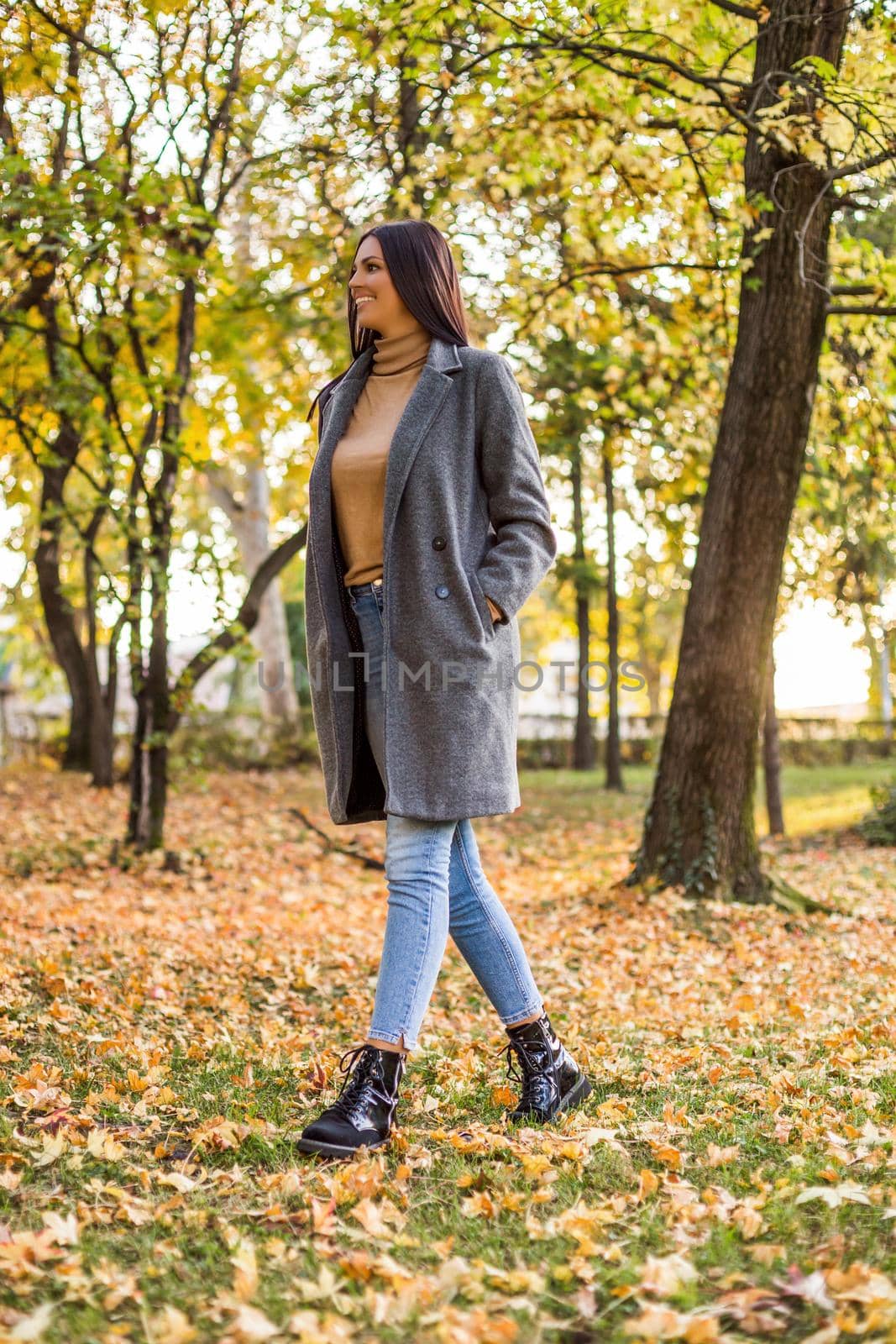 Beautiful woman walking in the park and enjoys in autumn.