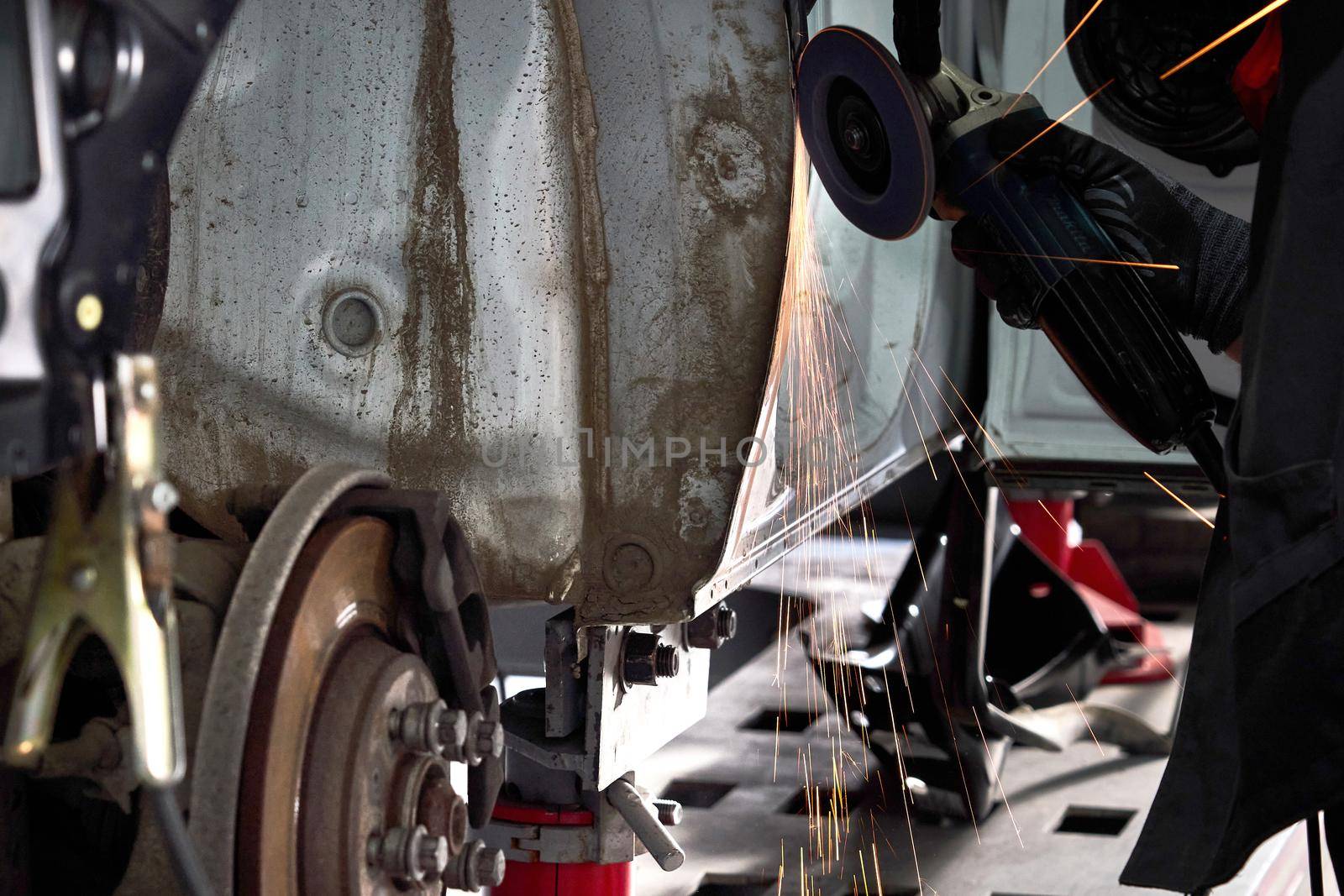 Cutting metal part with sparks in car service station