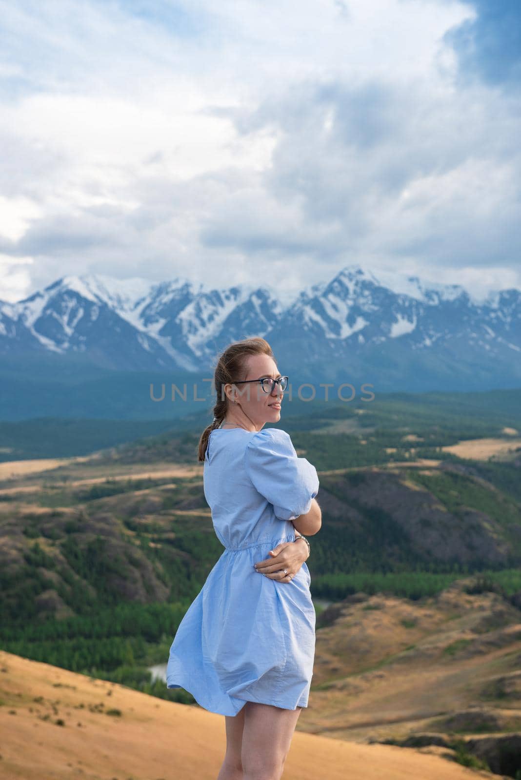 Woman in blue dress in summer Altai mountains in Kurai steppe