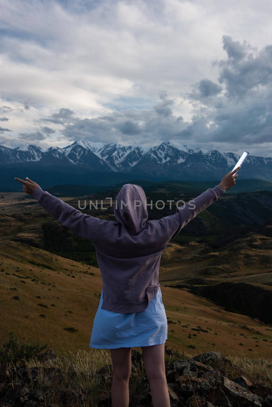 Woman with flashlight in summer Altai mountains in Kurai steppe