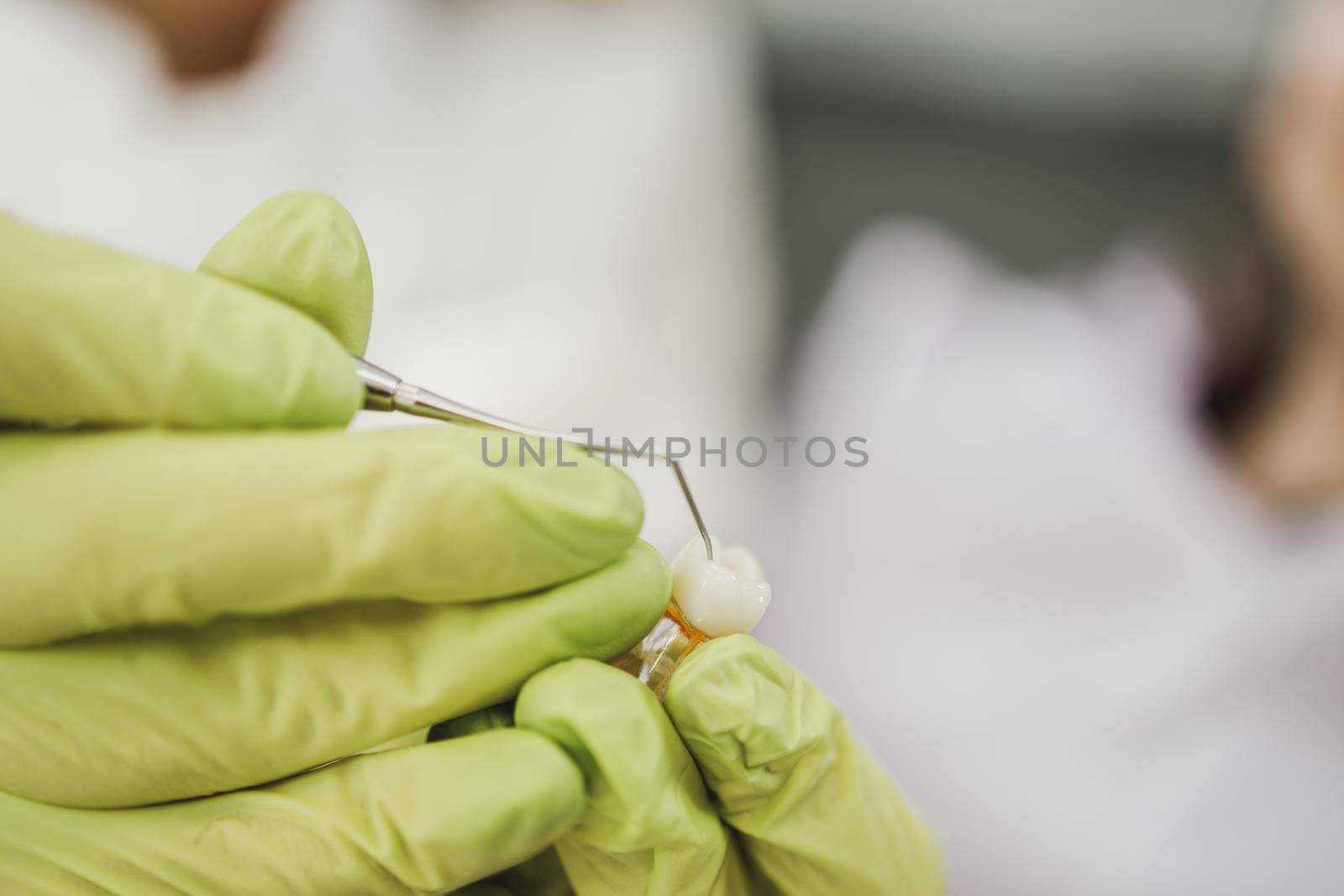 Shot of an unrecognisable dentist holding model of teeth in an office.