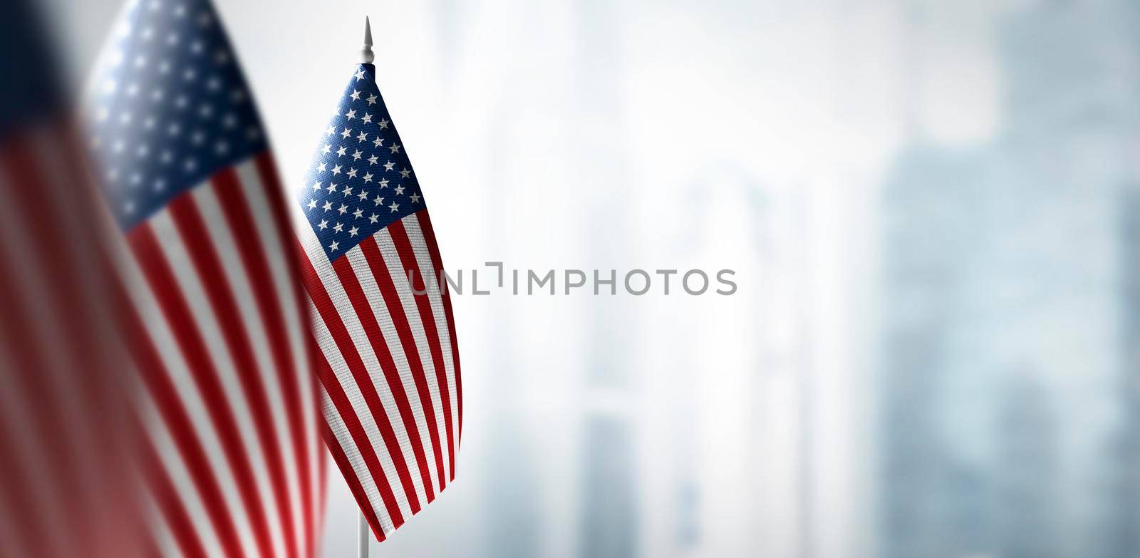 Small flags of United States on the background of a blurred background.