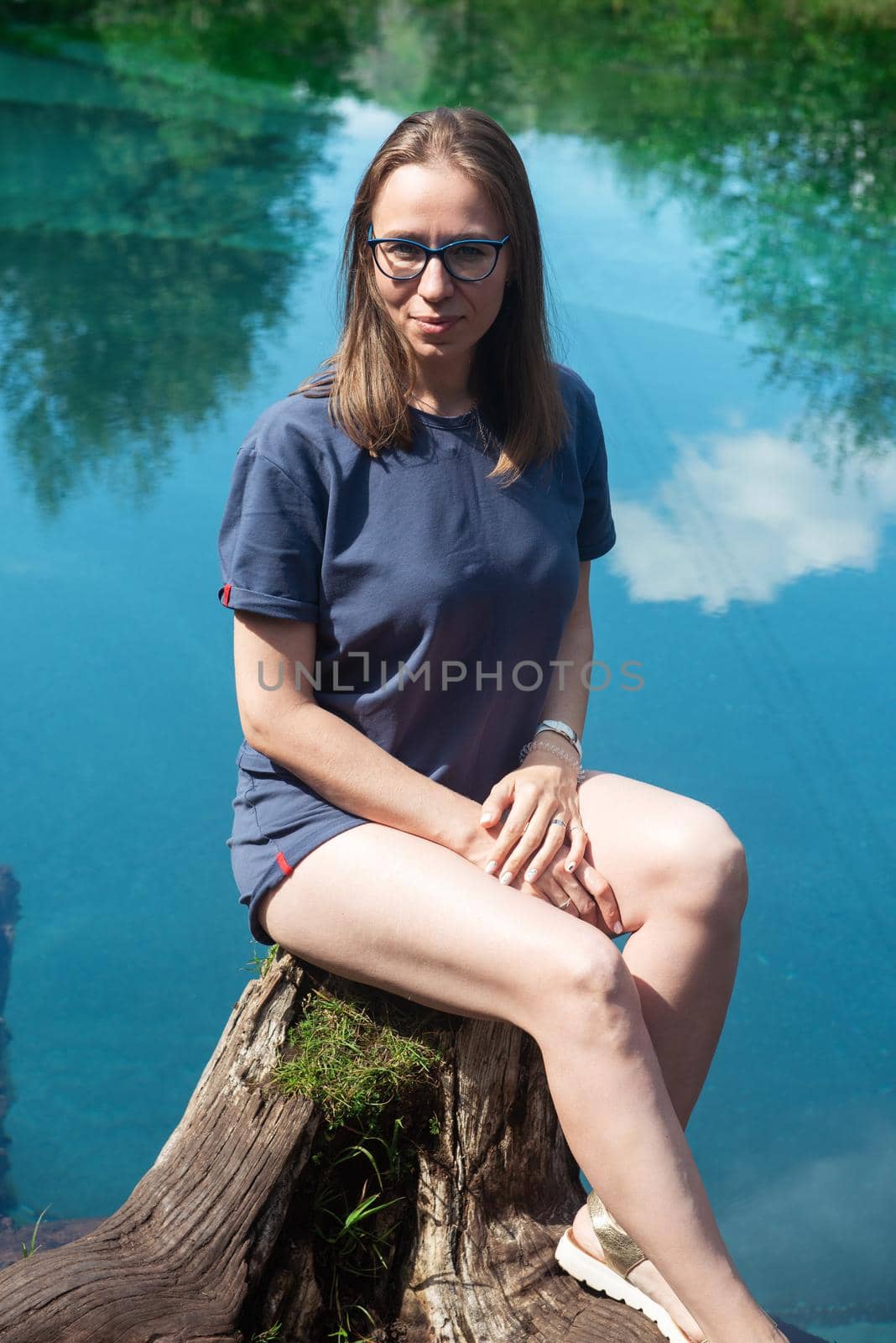 Woman at Beautiful Geyser lake with thermal springs that periodically throw blue clay and silt from the ground. Altai mountains, Russia