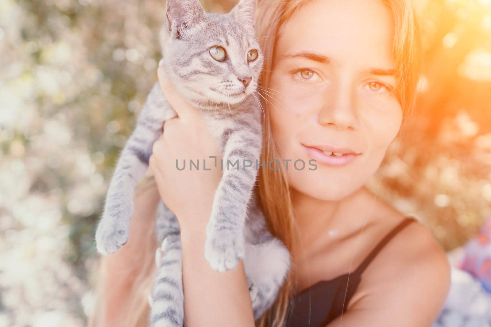 Woman summer travel cat. A woman on vacation with her pet cat enjoying a photo session on the beach. Travel and holiday concept. by panophotograph