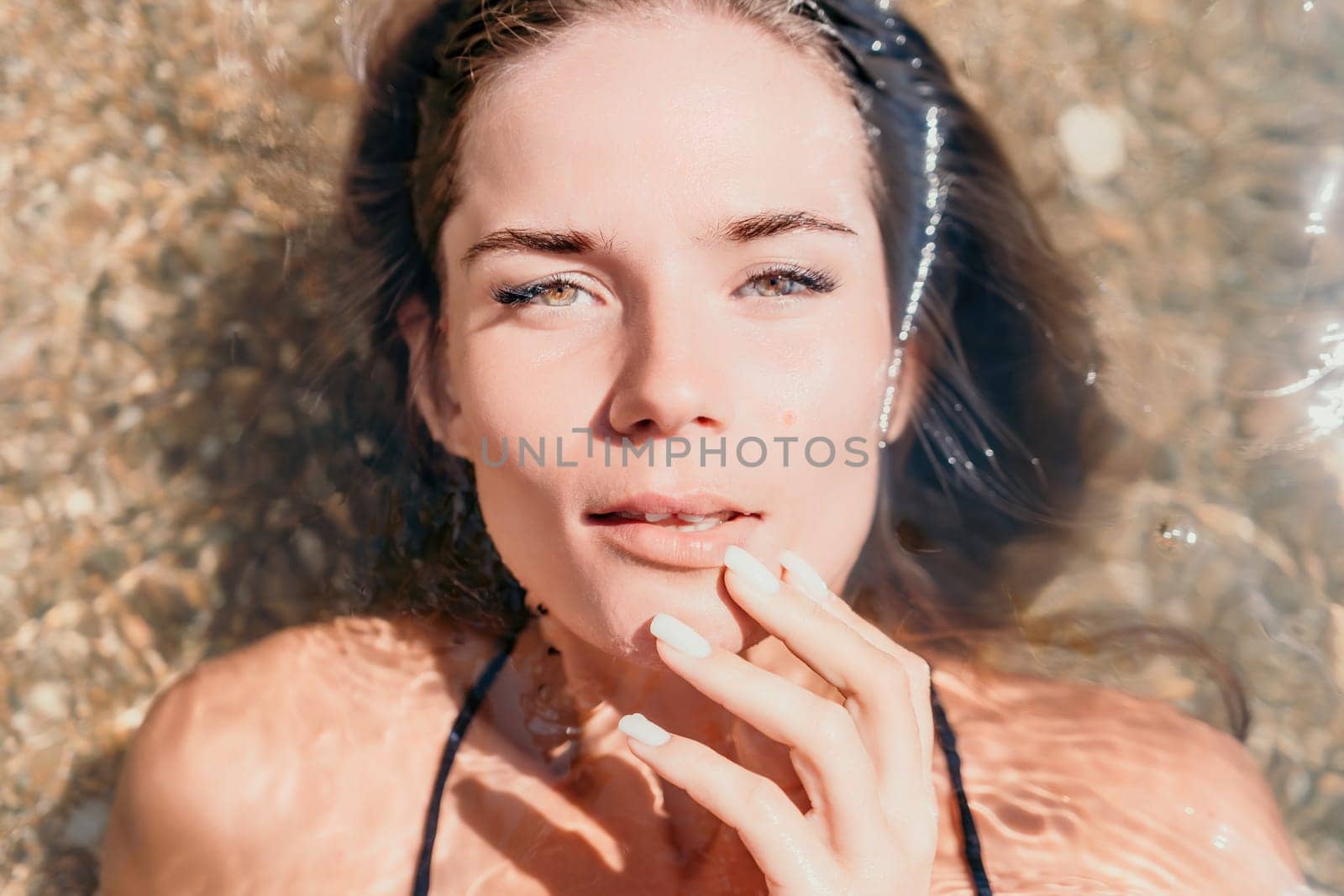 Woman summer travel sea. Happy tourist enjoy taking picture outdoors for memories. Woman traveler posing on the beach at sea surrounded by volcanic mountains, sharing travel adventure journey by panophotograph