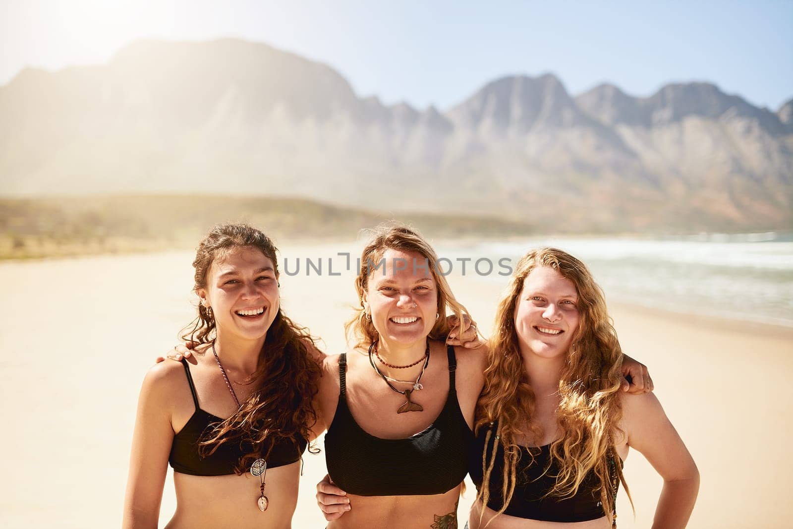 Yoga is the key to happiness. three beautiful young women at the beach for a yoga session
