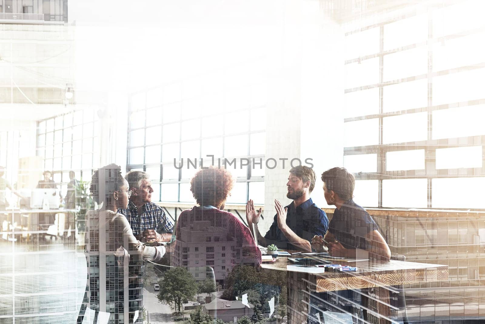 Multiple exposure shot of businesspeople having a meeting superimposed over a cityscape.