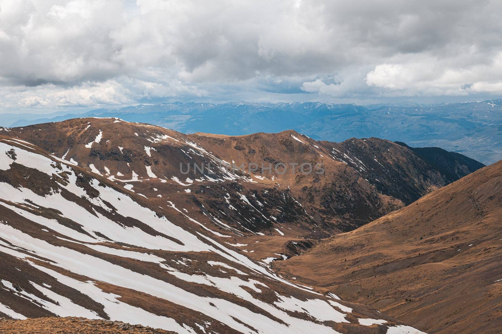 Panoramic view of the high snowy mountain ranges of the Pyrenees on an autumn day on a cloudy sky. Travel concept for climbing and skiing enthusiasts. Copyspace by apavlin