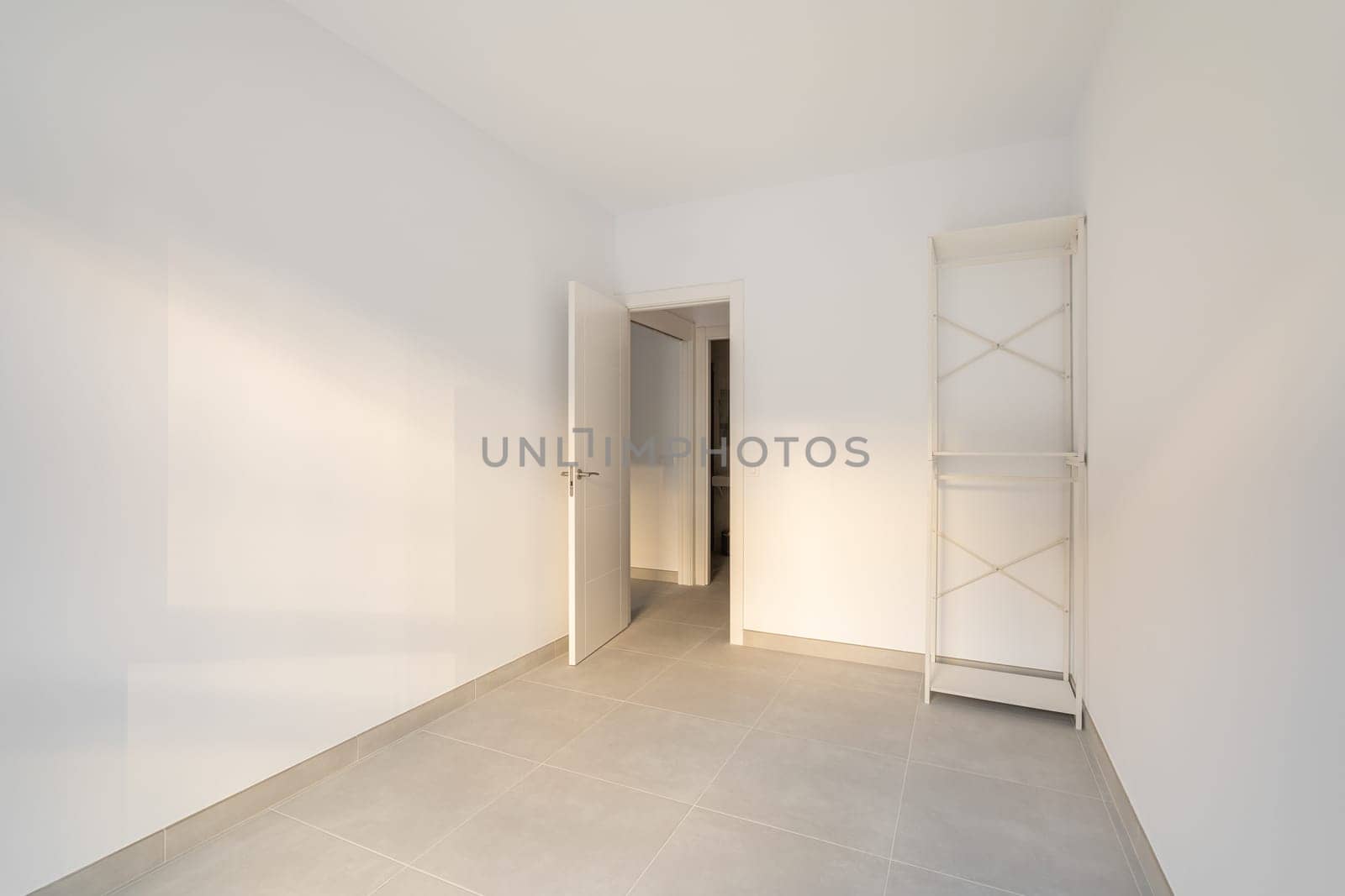 Narrow empty room with a closet and a door overlooking the corridor and other rooms. Concept of the apartment after the delivery of a new building or renovation. Copyspace by apavlin