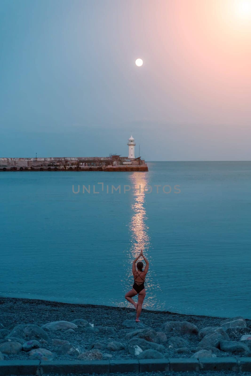 Woman The full moon rises to the lighthouse, the lunar path along the sea leads to the woman