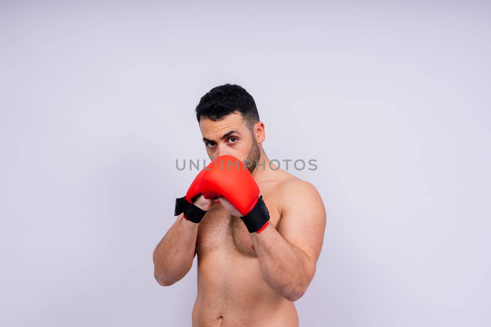 Man boxer in red sport boxing gloves at a studio, copy space.