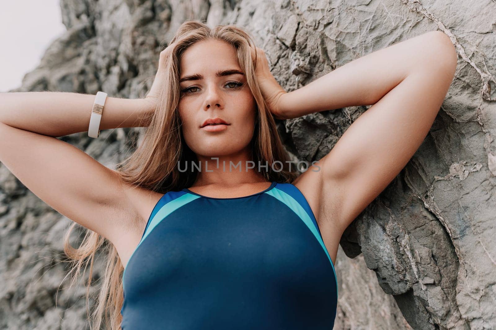 Woman summer travel sea. Happy tourist in blue bikini enjoy taking picture outdoors for memories. Woman traveler posing on the beach surrounded by volcanic mountains, sharing travel adventure journey by panophotograph