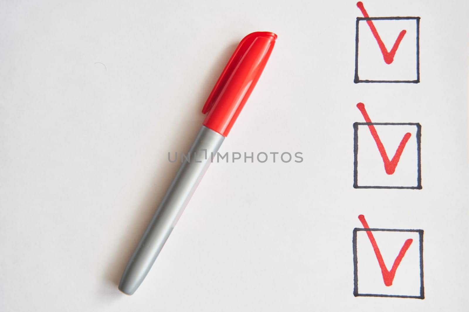 Checklist marked red with a red pen. Close up shot of filled check boxes with red pen