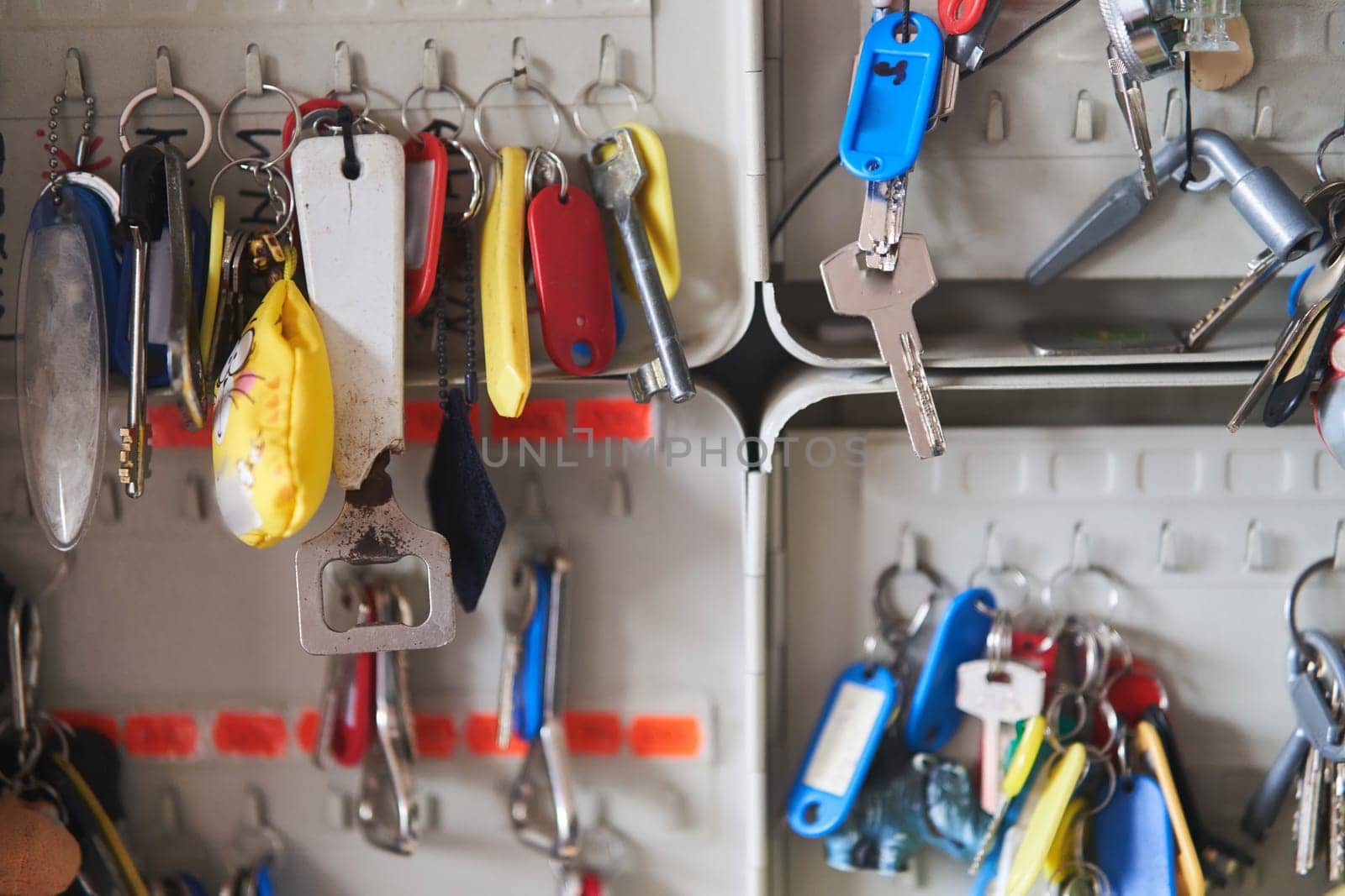 many keys with multi-colored key chains hang in the key keeper by driver-s