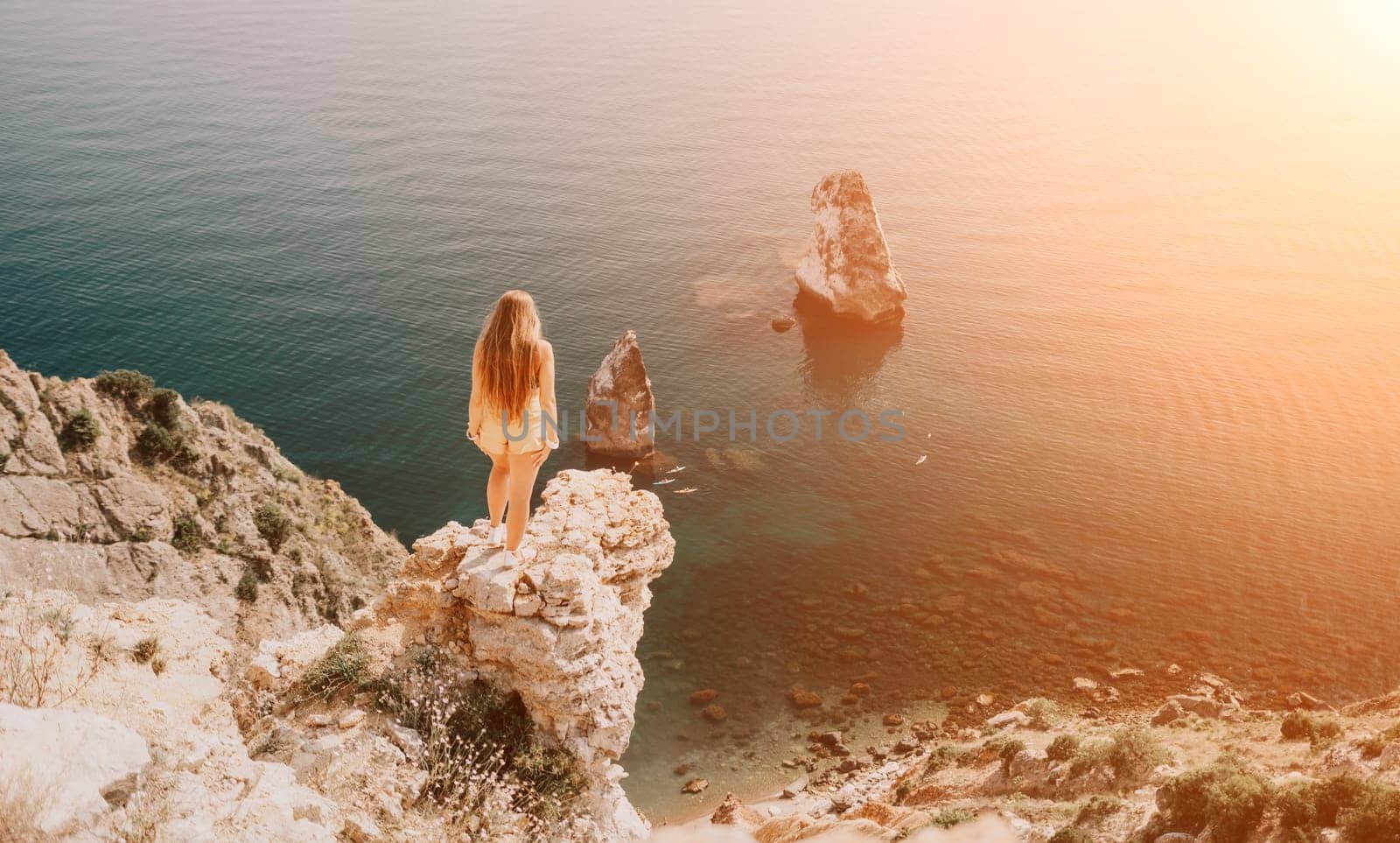 Woman travel sea. Happy tourist enjoy taking picture outdoors for memories. Woman traveler looks at the edge of the cliff on the sea bay of mountains, sharing travel adventure journey by panophotograph