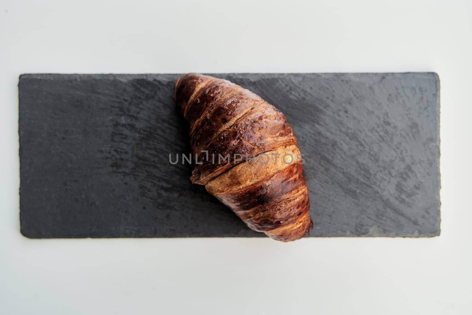 Croissant on a black tray top view by driver-s