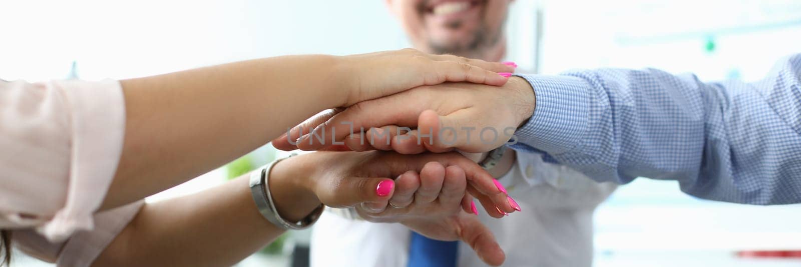 Business people put their hands together in office closeup by kuprevich