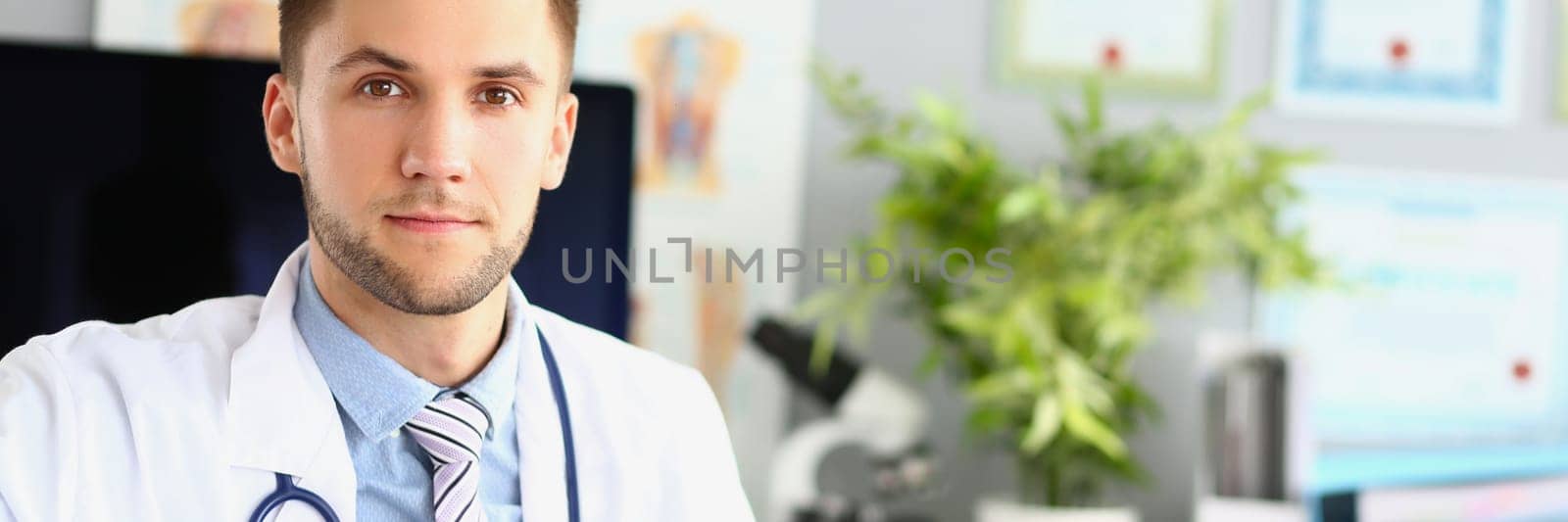 Portrait of young doctor therapist cardiologist in clinic. Medical care doctor appointment or insurance concept
