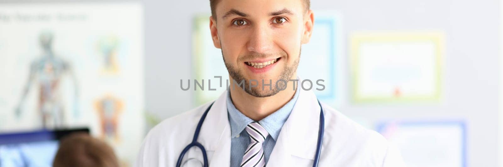 Portrait of handsome male doctor in modern clinic. Health insurance and services concept