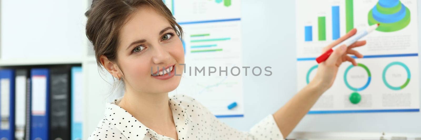 Female mentor conducts training in marketing and analytics in charts. Business woman holding a business development conference