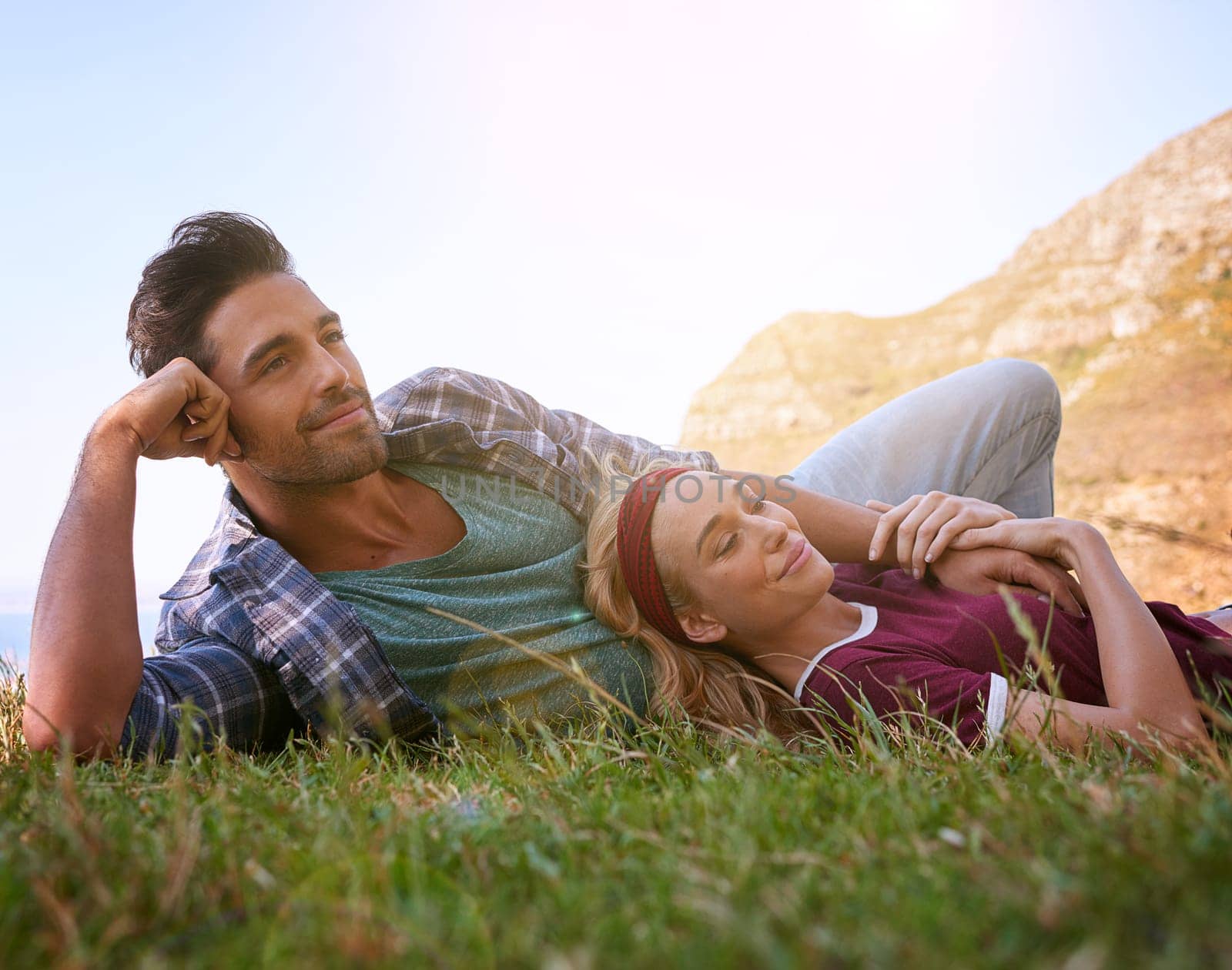 Relax, smile and love with couple in nature for mountains, bonding and affectionate. Happiness, date and romance with man and woman cuddle in grass field for summer break, happy and relationship by YuriArcurs