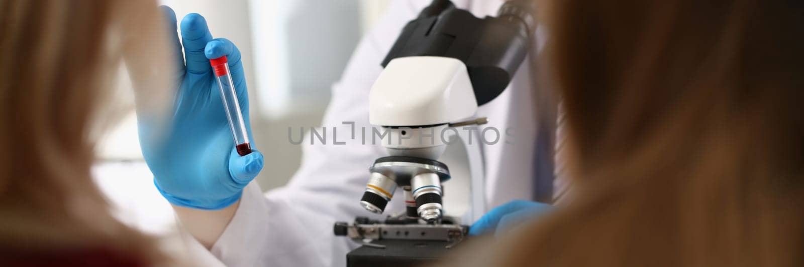 Scientists in the laboratory examine blood sample in sample tube. Dna analysis concept