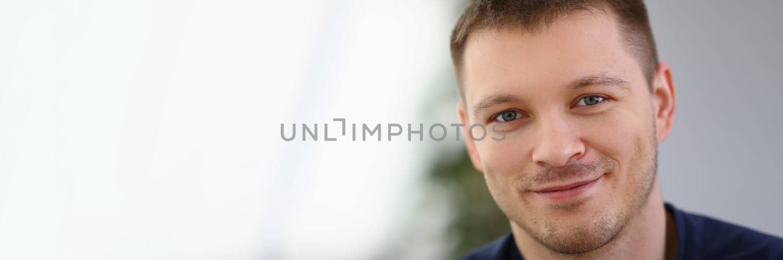 Portrait of handsome smiling young man with stubble. Positive emotions concept