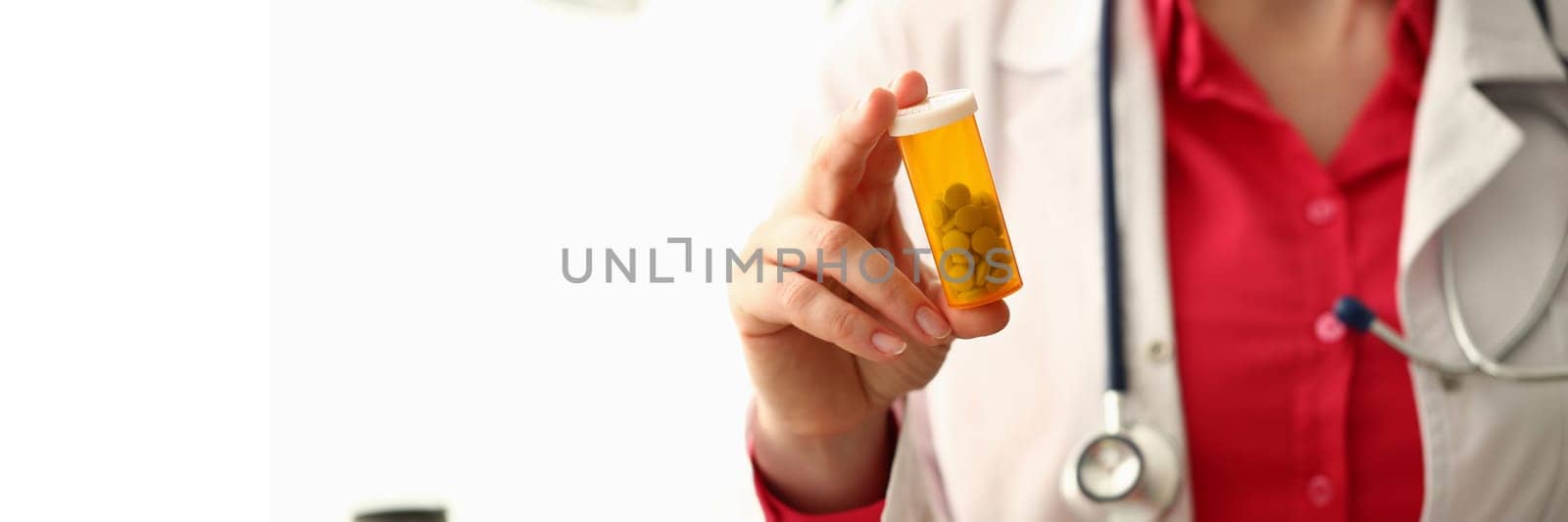 Closeup of doctor holding container of medical pills by kuprevich
