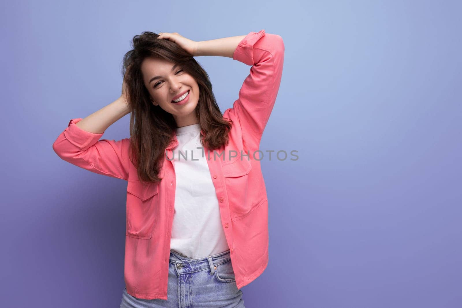 well-groomed european brunette 30s woman in pink shirt on studio background by TRMK