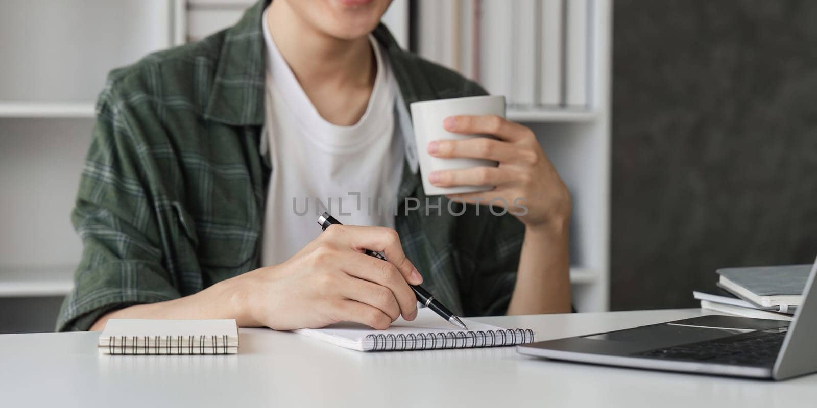 Man working with laptop computer and drink coffee in living room.