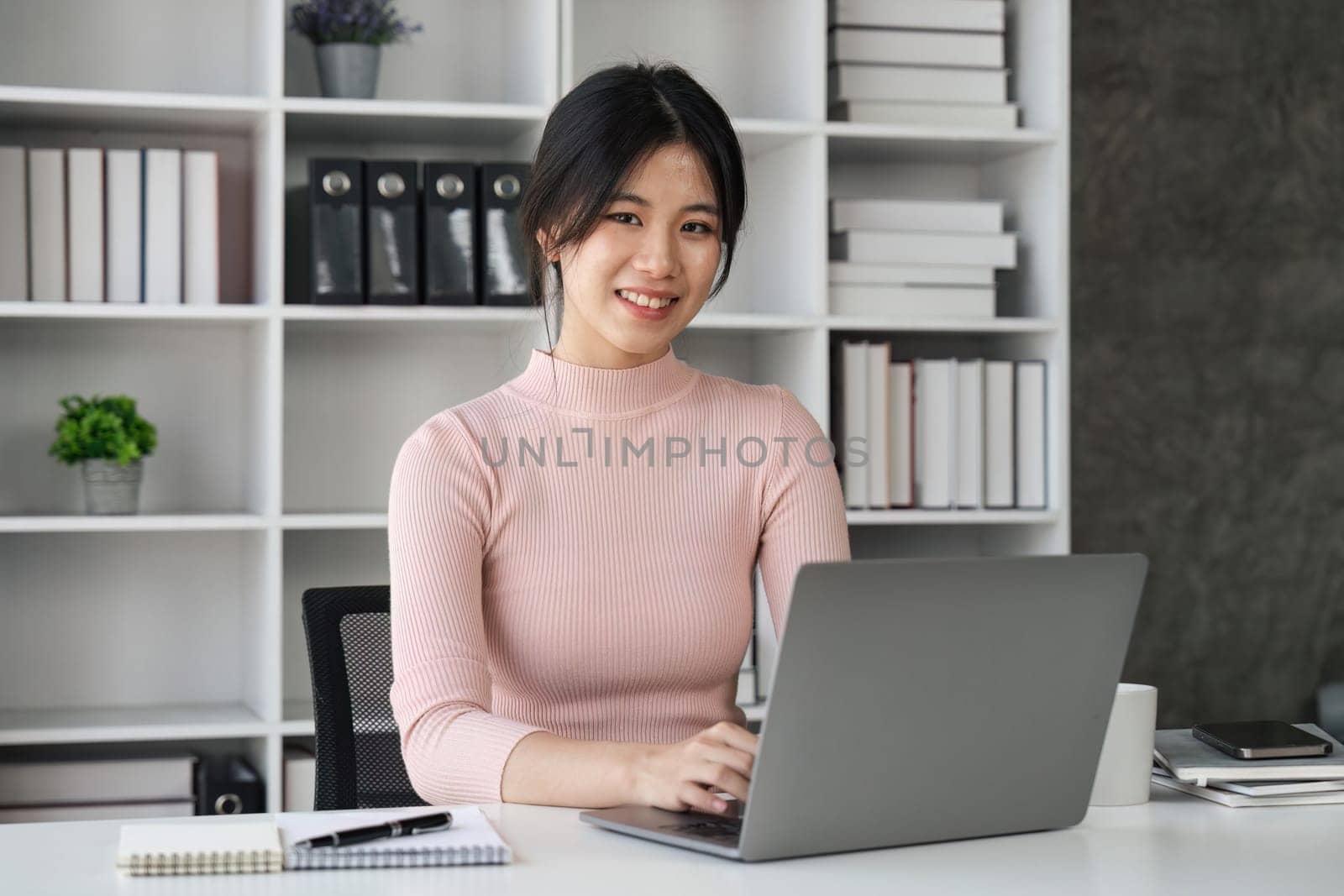 Beauitul young woman working using computer laptop smile looking at camera.
