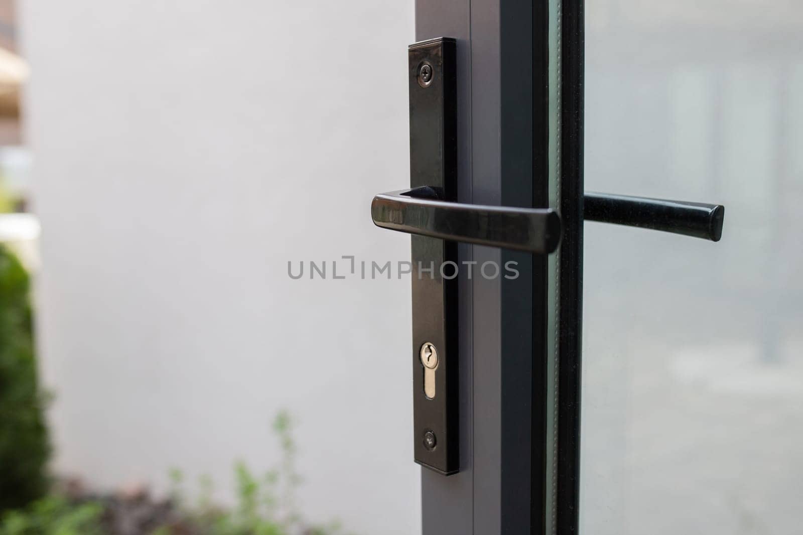 Door handle with lock on a glass door with access to the backyard.