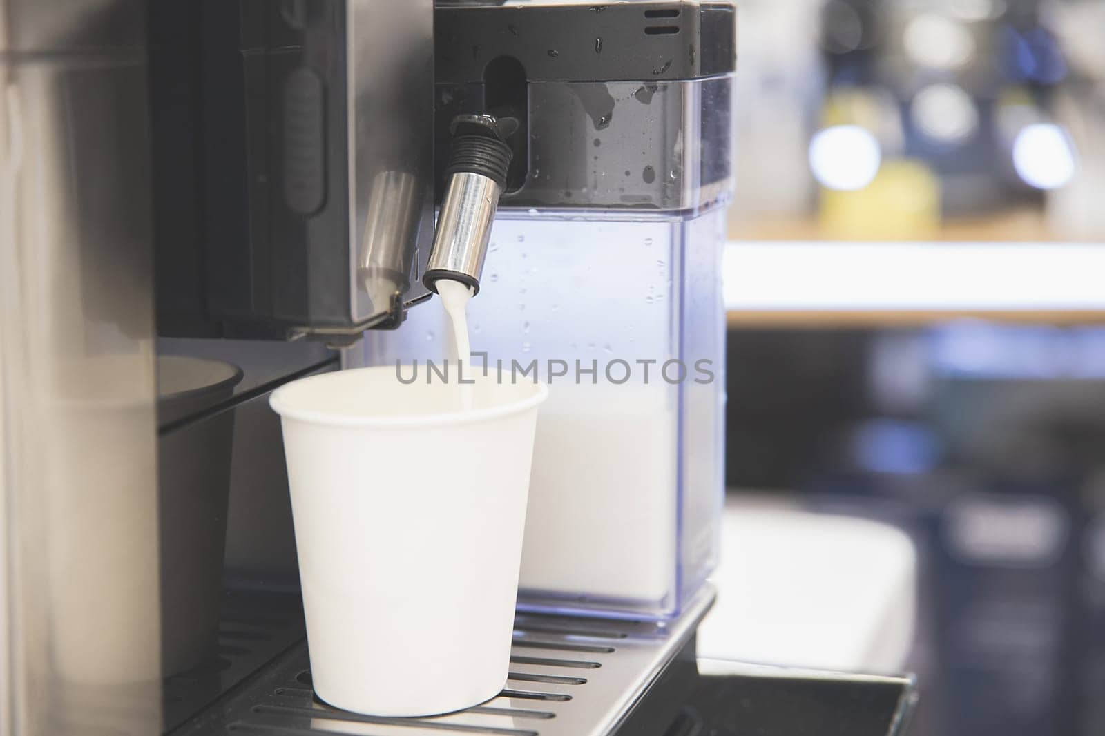 Cappuccino is poured into a white paper cup, take your coffee with you by Rom4ek