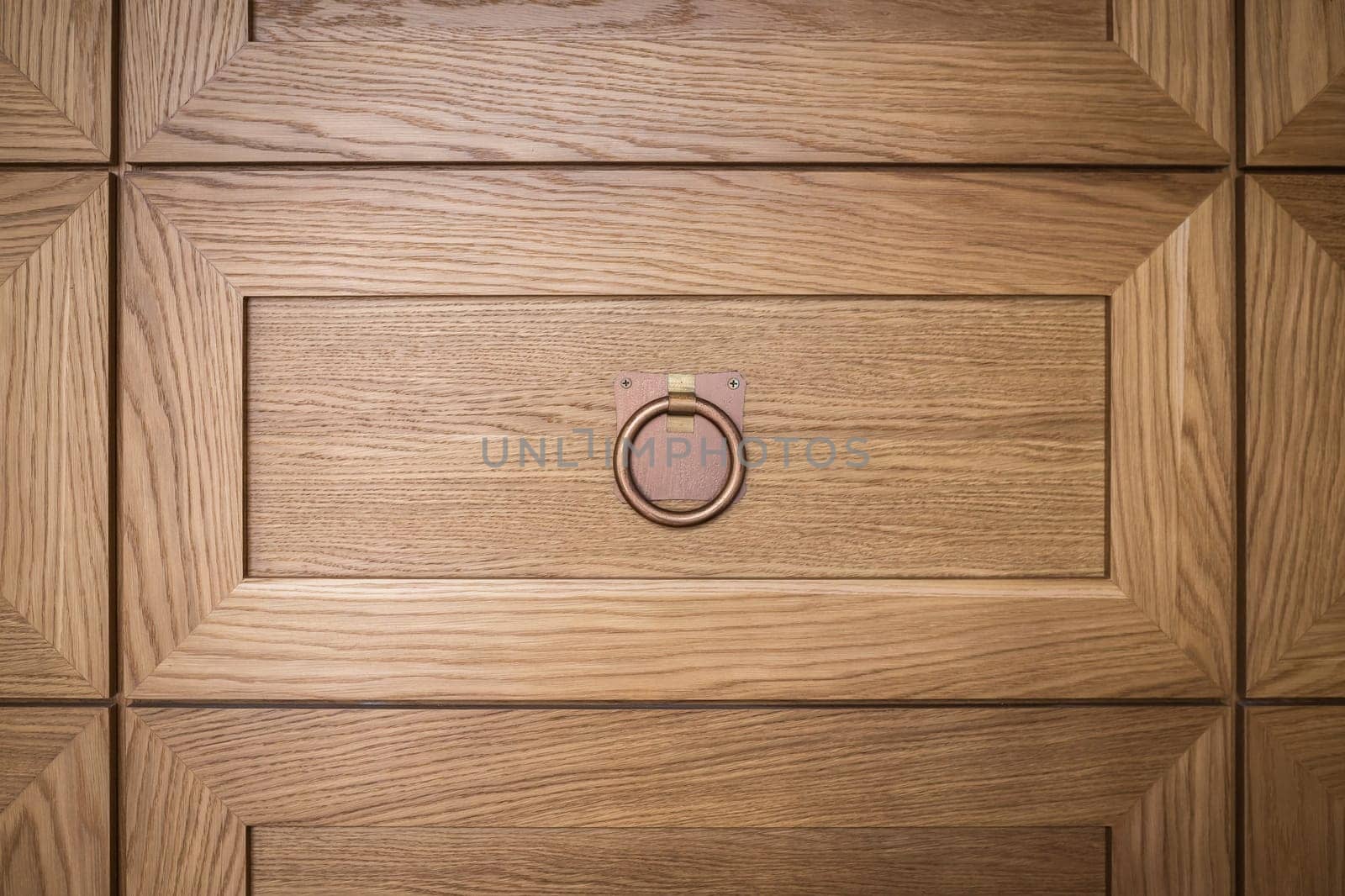 Close-up detail of a decorative wall in the form of many panels of drawers with a handle.