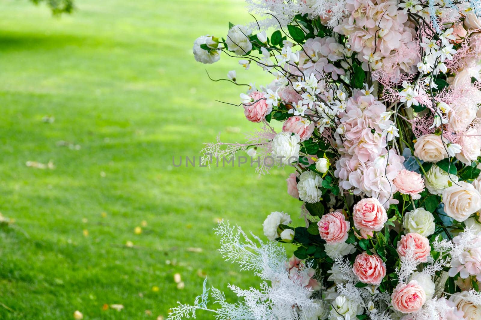 Various European flowers on the right side of the photo in front of a green lawn field. High quality photo