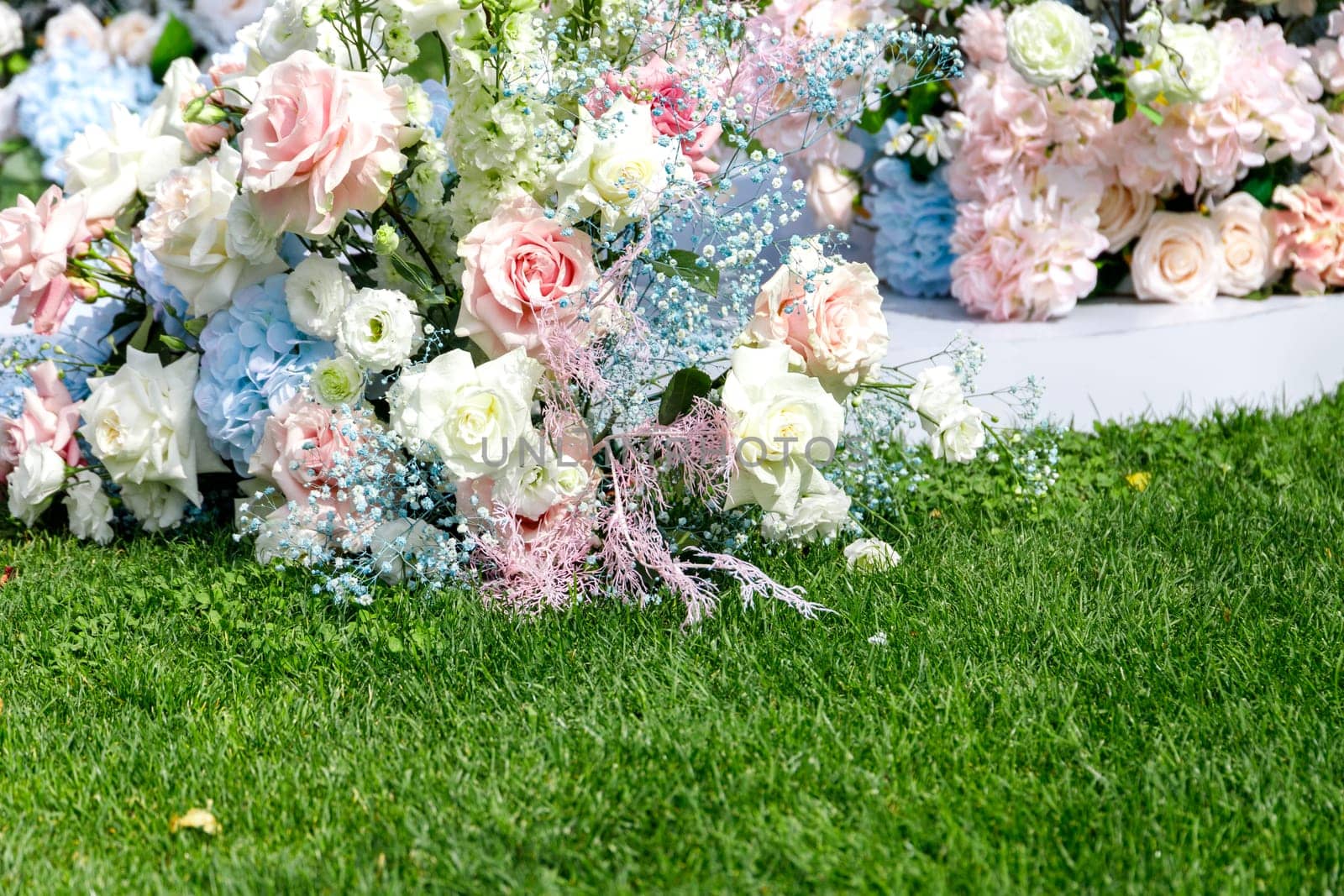 Green summer lawn and part of festive wedding flower decorations, copy space.