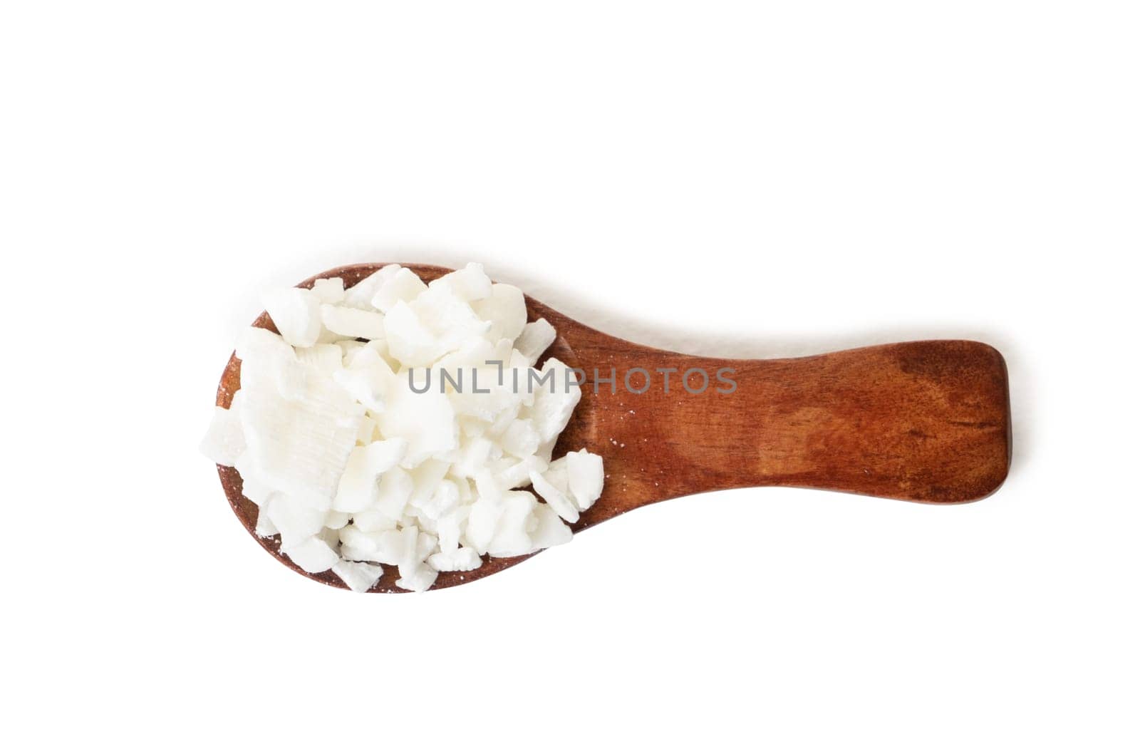 Organic white soy wax flakes for candles in small measure spoon isolated on white background with shadow