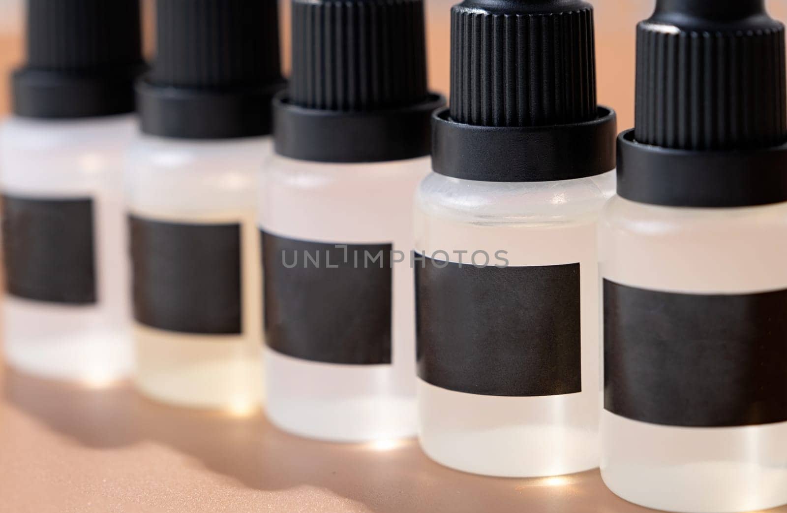 Set of plastic dropper bottles with liquid with black blank stickers. Mockup on brown background with shadow