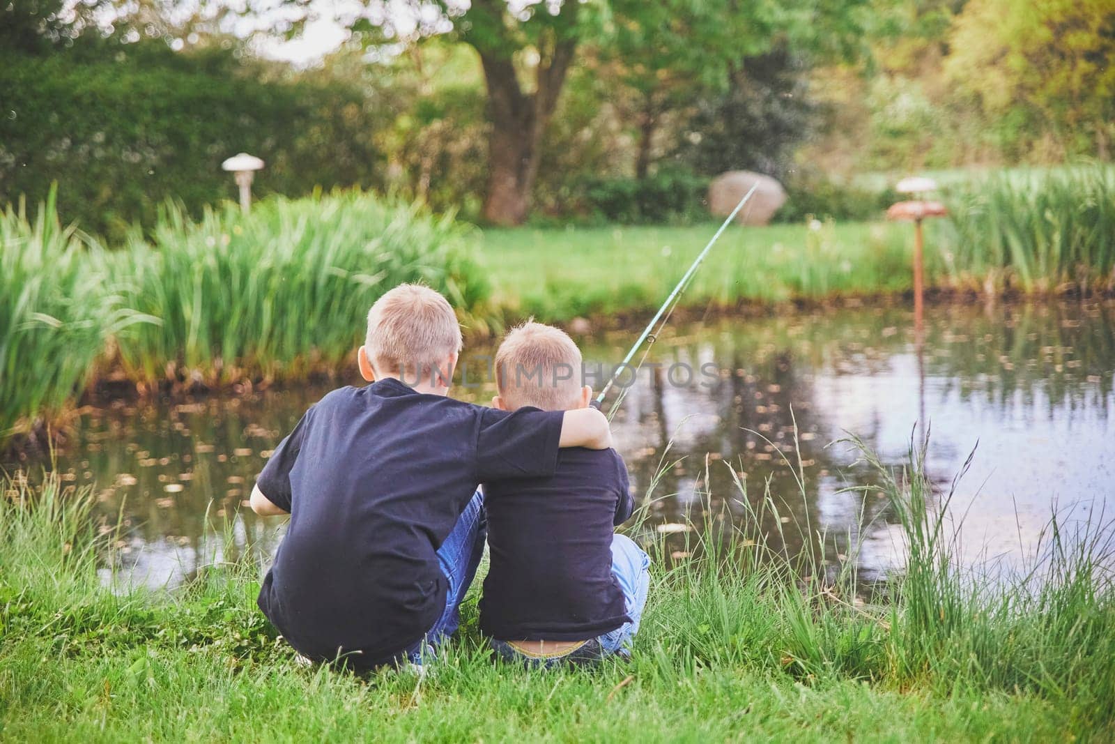 Two brothers are fishing in the lake in Denmark.