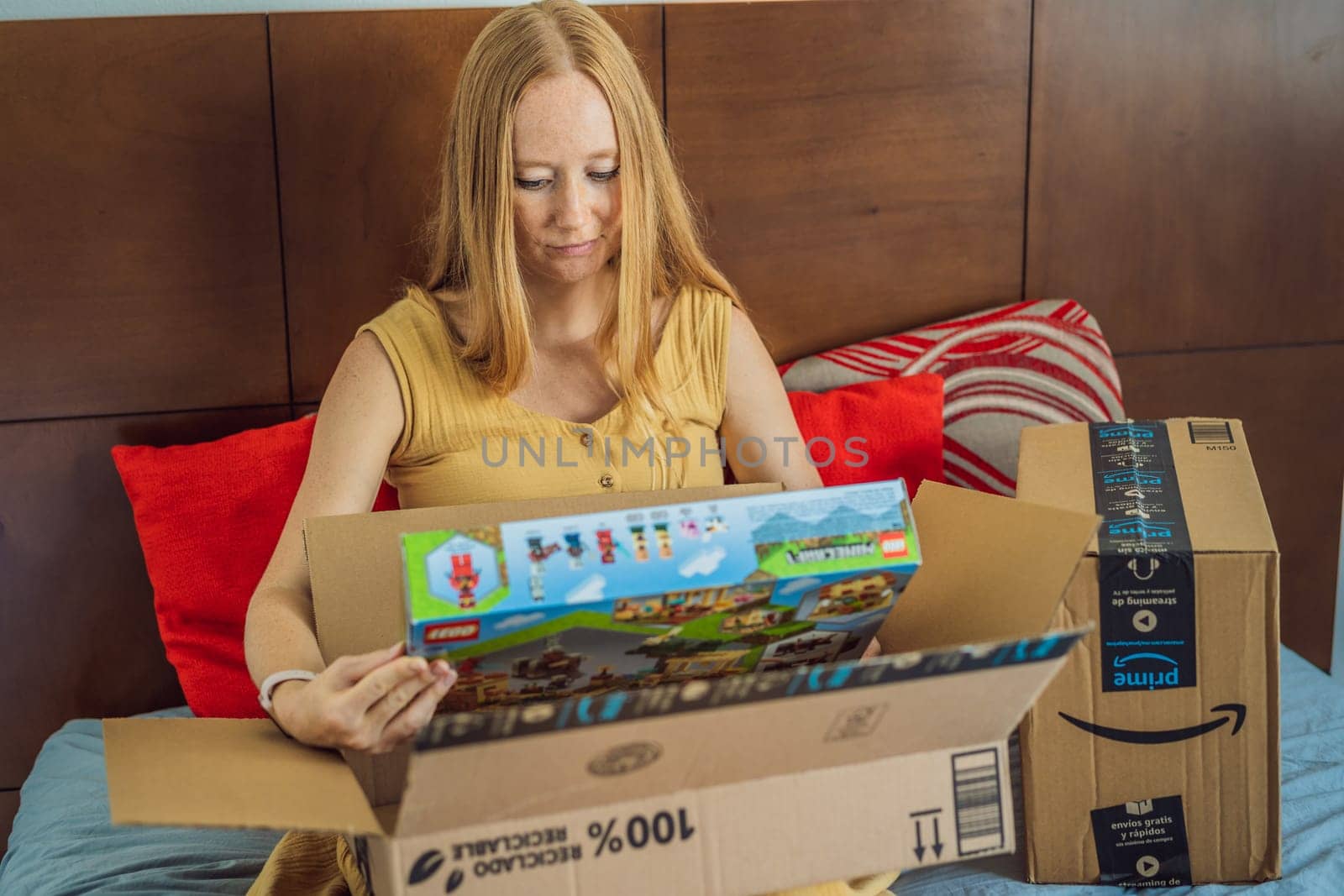 12.21.22, Mexico, Playa del Carmen: A pregnant woman received a package from Amazon. A woman takes a Lego set out of the box for her eldest son. Online shopping during pregnancy by galitskaya