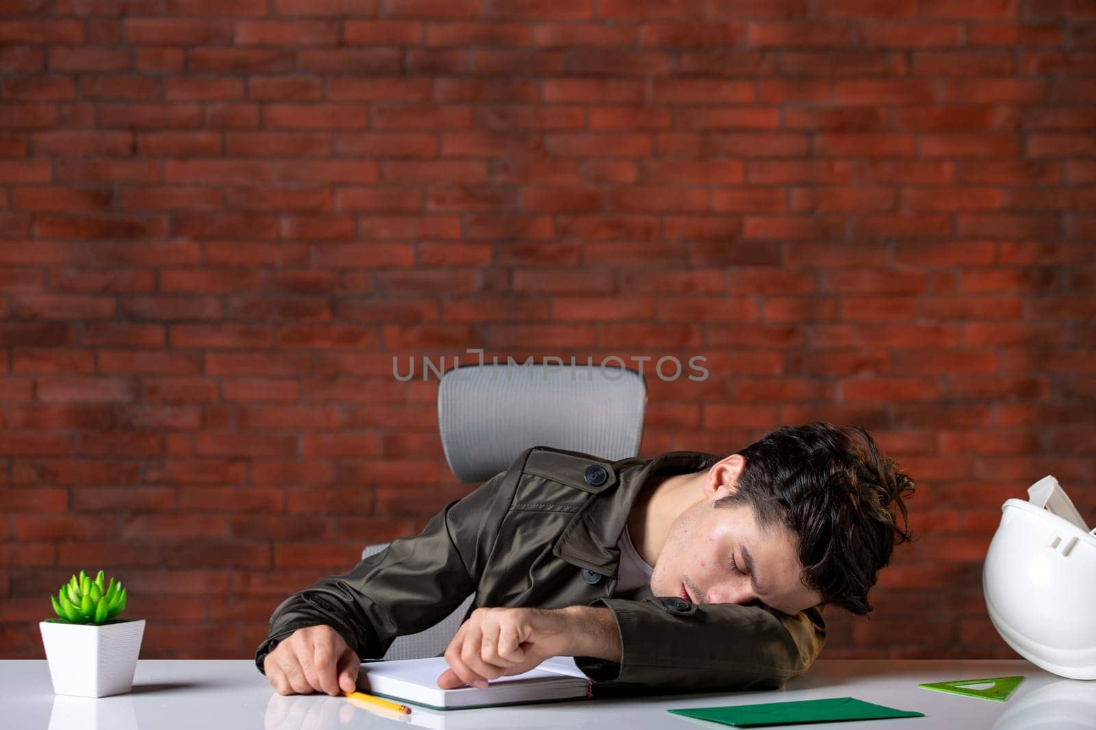 front view male engineer sitting behind his working place and falling asleep document plan job business corporate contractor property builder