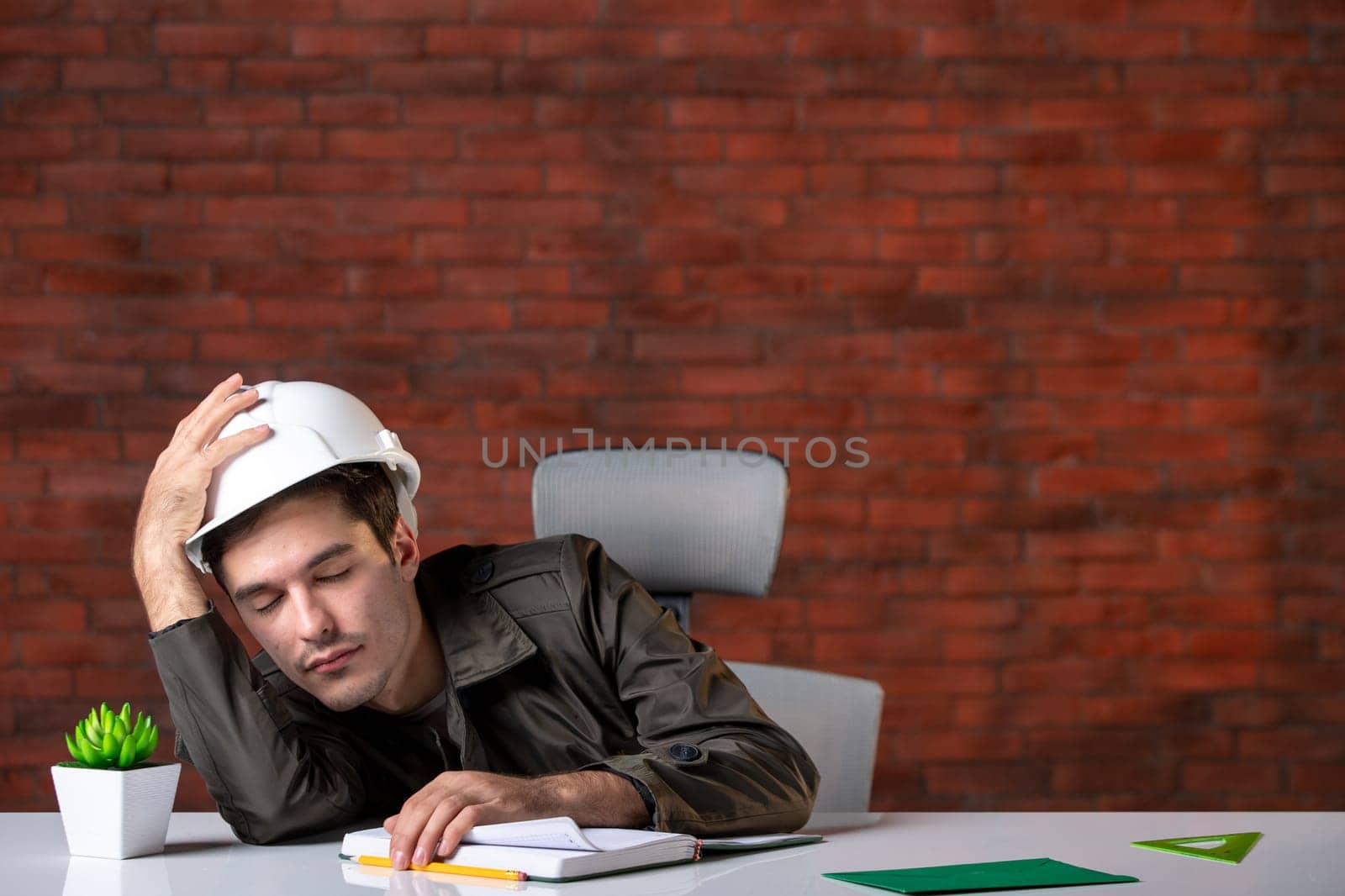 front view male engineer sitting behind his working place and falling asleep document plan job corporate contractor agenda property builder