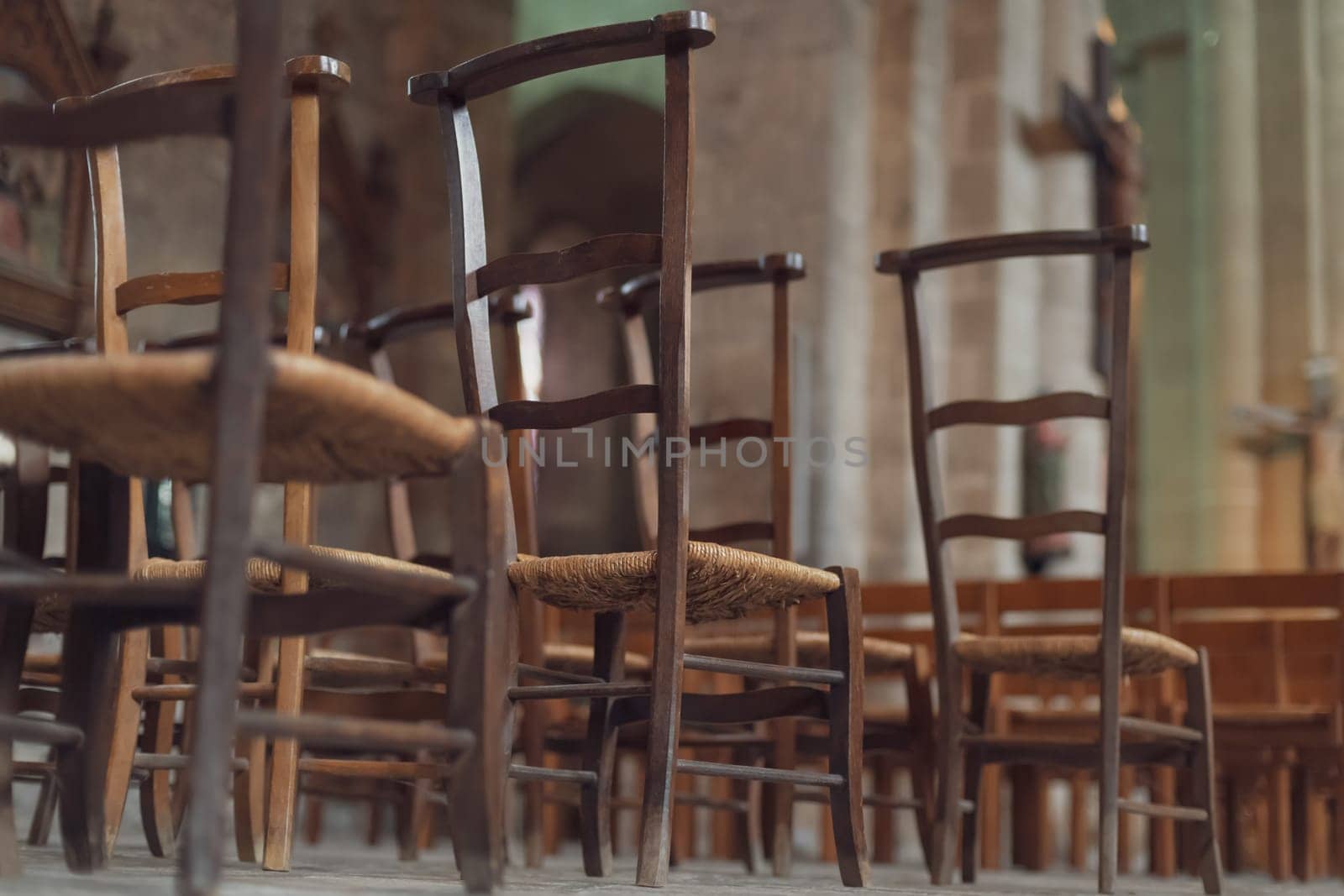 Row of wooden chairs inside in a church in France.
