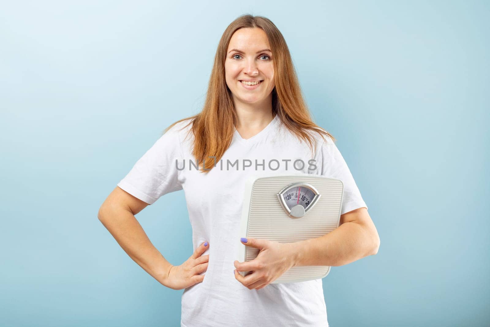 Young woman holding white scales to check the results of her diet by andreyz