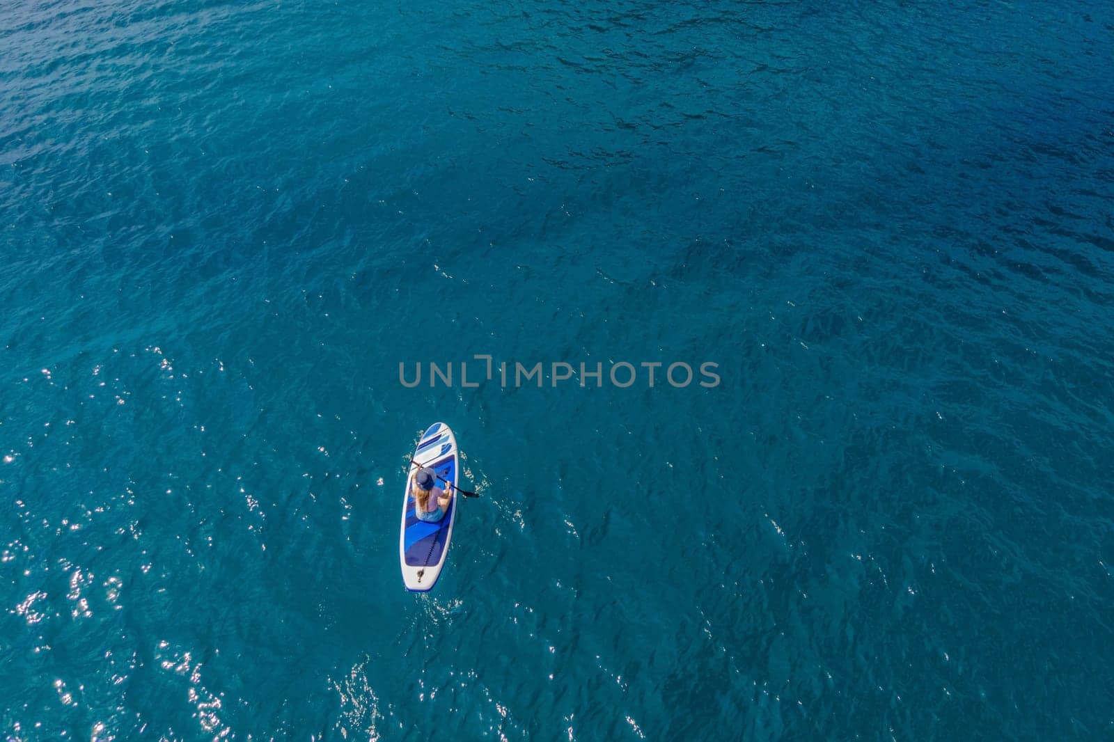 Young women Having Fun Stand Up Paddling in blue water sea near st stefan island in Montenegro. SUP.