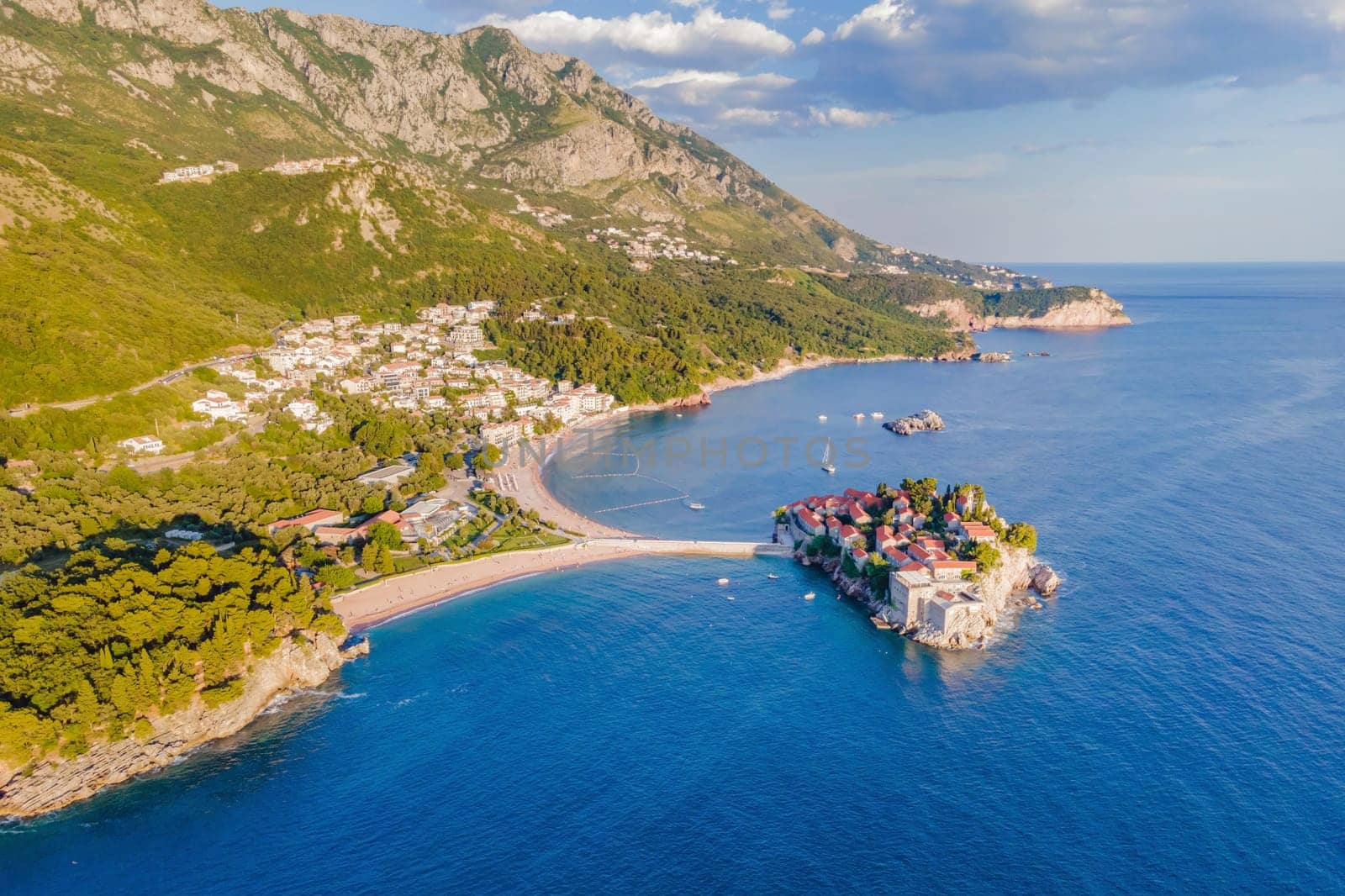 Aerophotography. Aerial view of Sveti Stefan island in a beautiful summer day, Montenegro from flying drone. Panoramic above view of Saint Stephen luxury resort. Tourism and leisure concept.