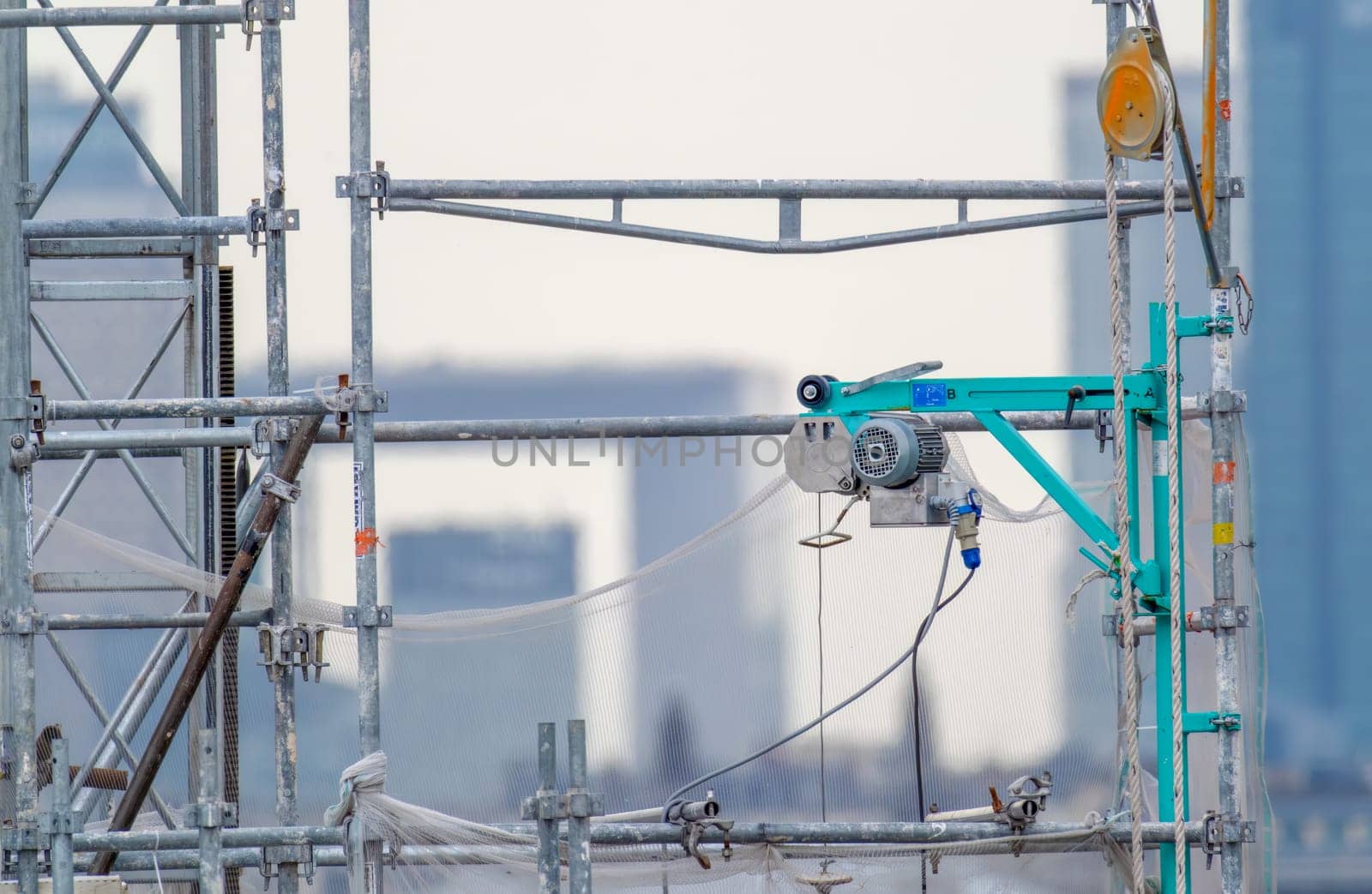 6 May 2023. Paris, France. Restoration and repair work continues in the city of Paris in preparation for the 2024 Olympics. A close up view of scaffolding, pulley, and equipment with La Defense grand arch in the background. Selective focus