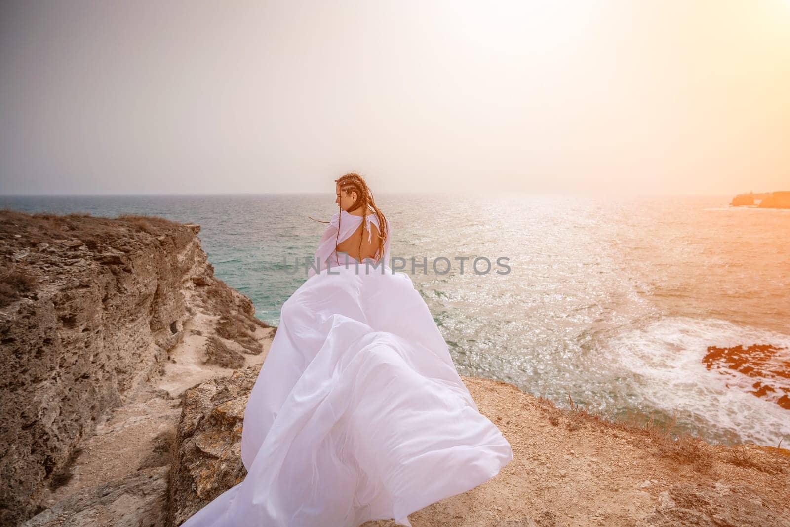 Woman sea white dress. Happy freedom woman on the beach enjoying and posing in white dress. Rear view of a girl in a fluttering white dress in the wind. Holidays, holidays at sea. by Matiunina